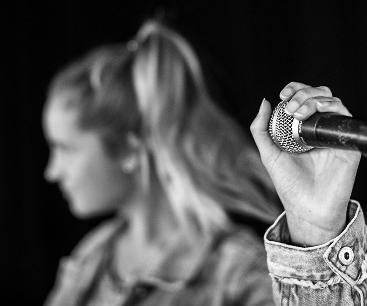 Tjej som håller i mikrofon.